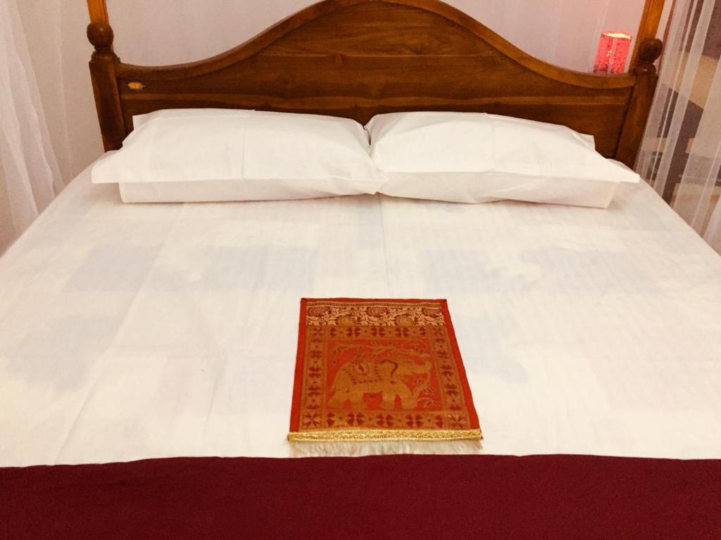 GadaladeniyaNew Toropi Homestay的一张带木制床头板和地毯的床