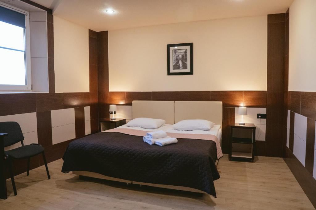 鲍里斯皮尔卡罗纳酒店的一间卧室配有一张床,上面有两条毛巾
