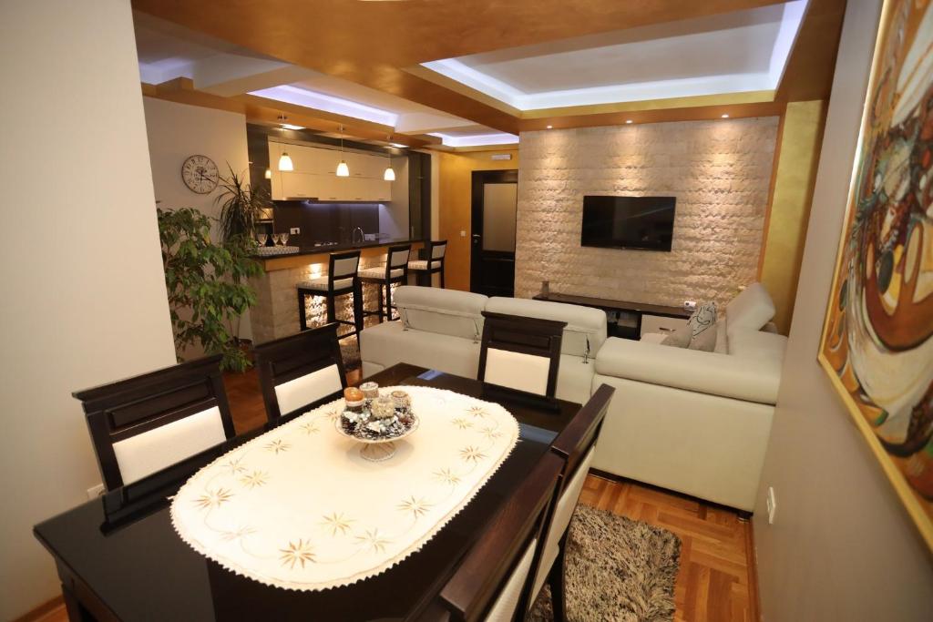 新瓦罗什Zlatar LUX Apartman的客厅配有桌椅和沙发