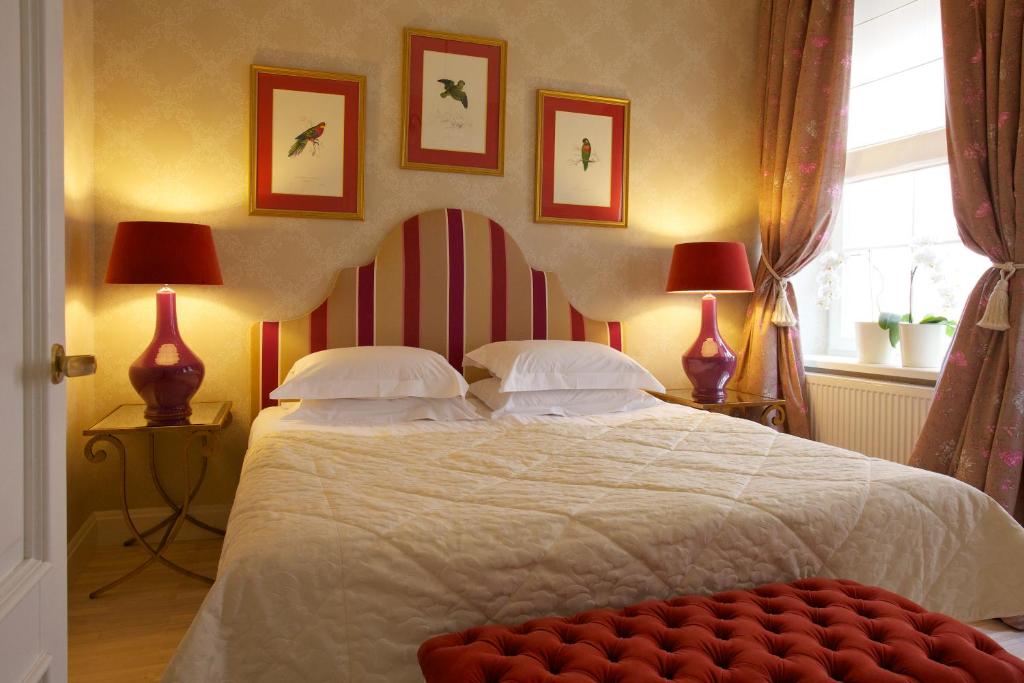 维尔纽斯阿皮亚酒店的一间卧室配有一张带两盏灯的大型白色床。
