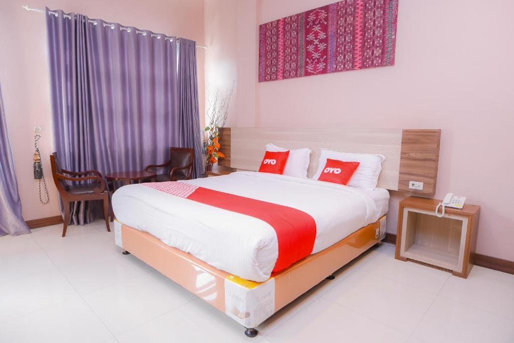 班达亚齐Super OYO Capital O 1630 Hotel Syariah Ring Road的一间卧室配有一张带红色枕头的大床
