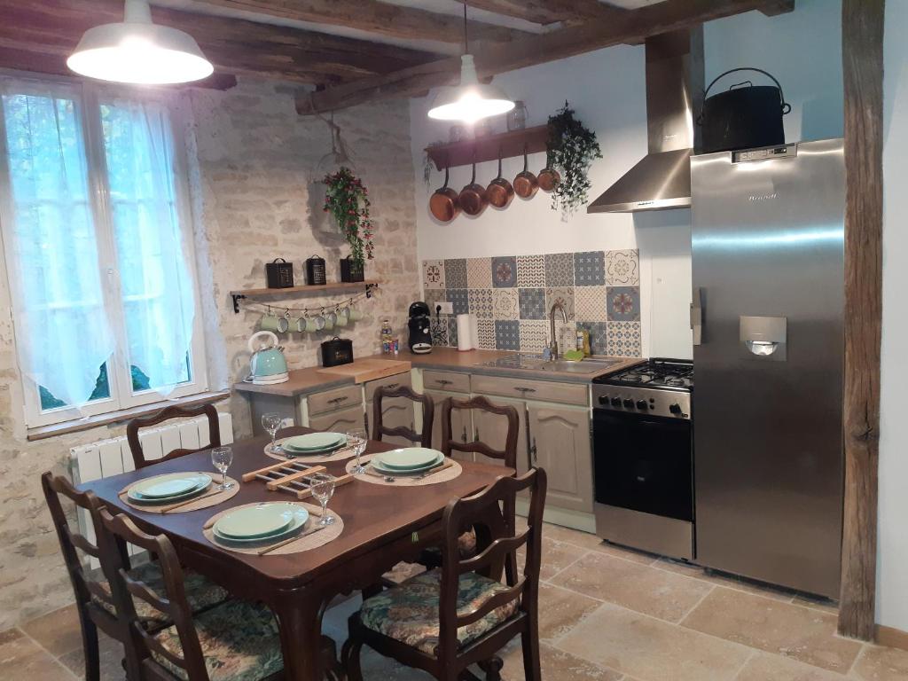 PolisyAU VIEUX PUIT的厨房配有桌椅和冰箱。