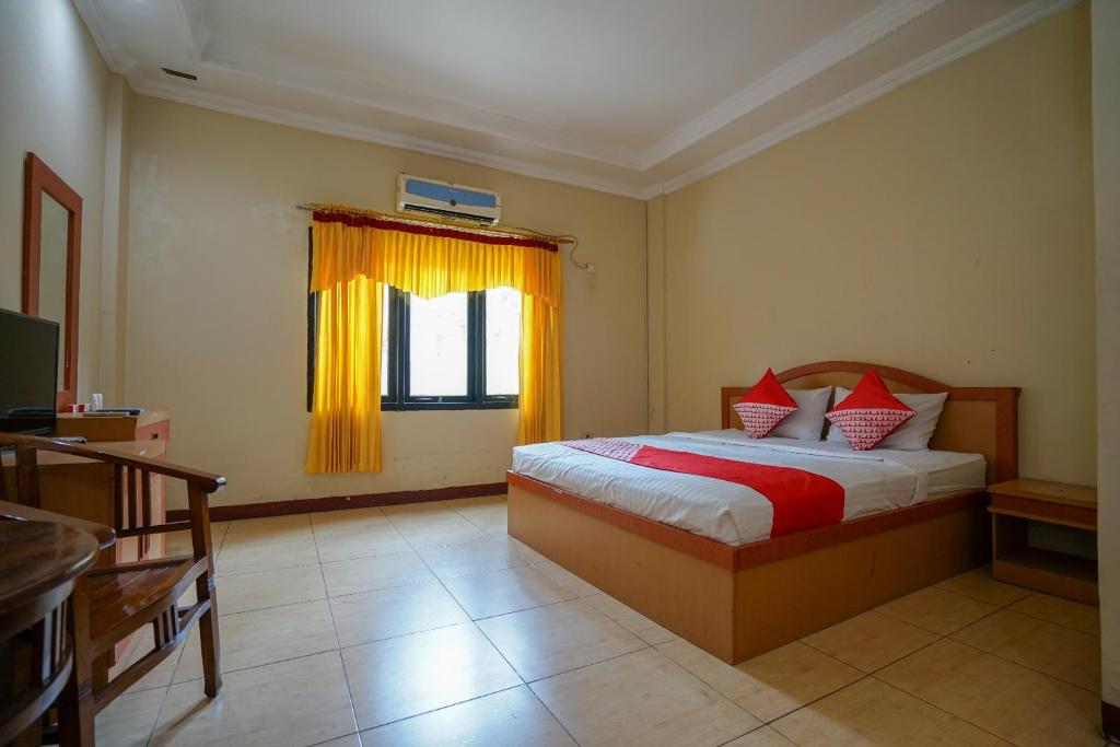 巨港OYO 1273 Hotel Belvena的一间卧室设有床和黄色窗帘的窗户