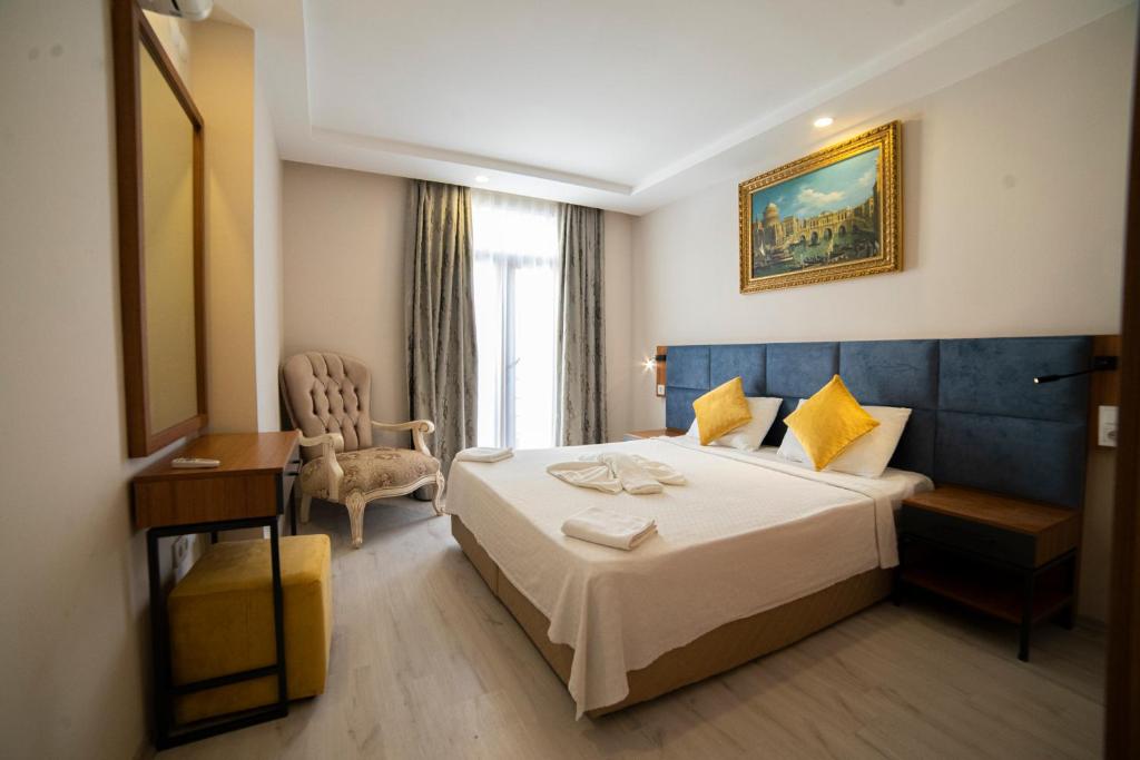 安塔利亚Sirena Apart & SPA的配有一张床和一把椅子的酒店客房