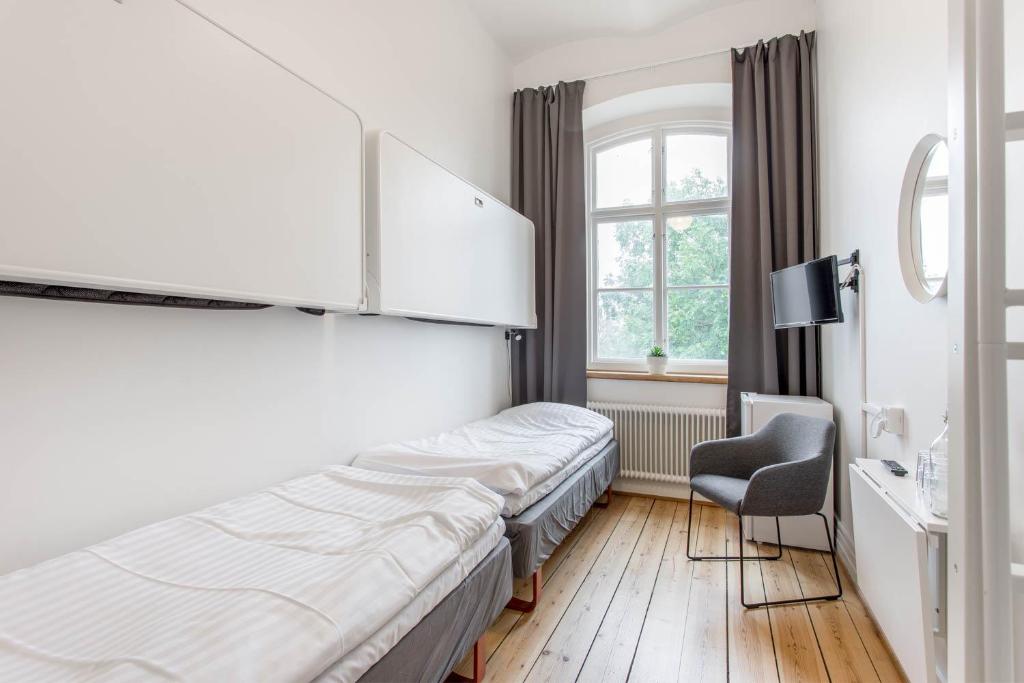 卡尔斯克鲁纳Kronohäktet的配有一张床和一把椅子的酒店客房
