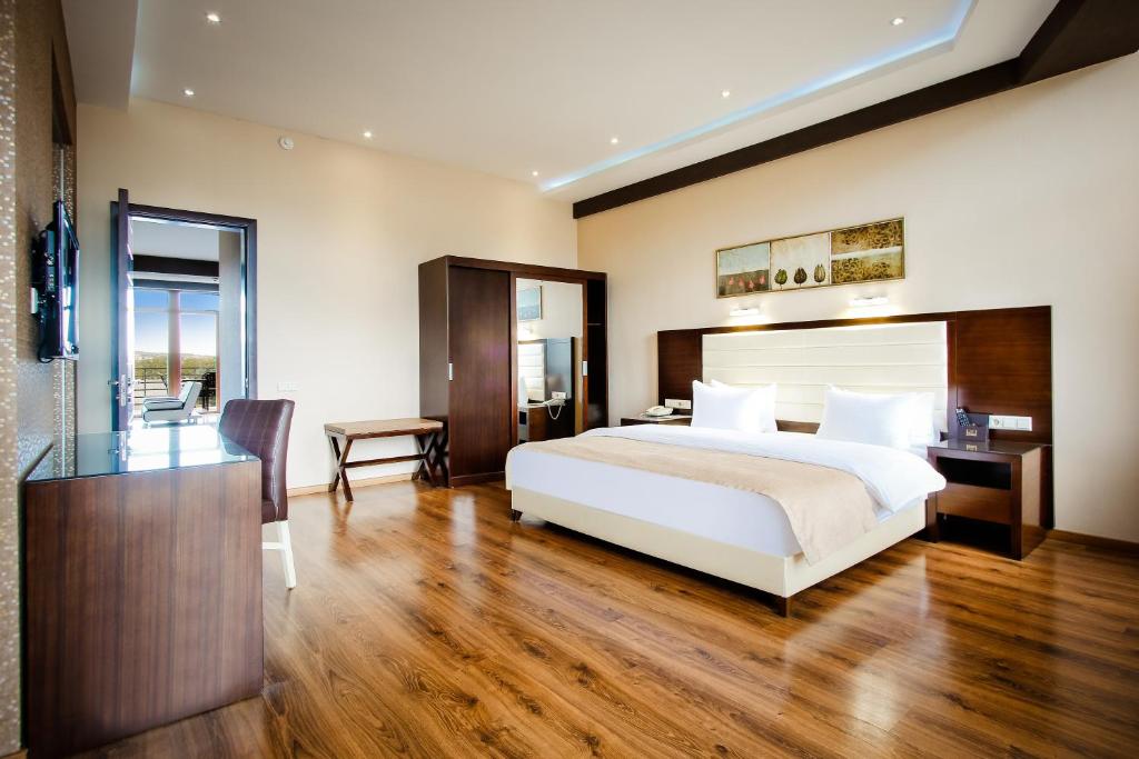 第比利斯Hotel Orion Tbilisi的卧室配有一张白色大床和一张书桌