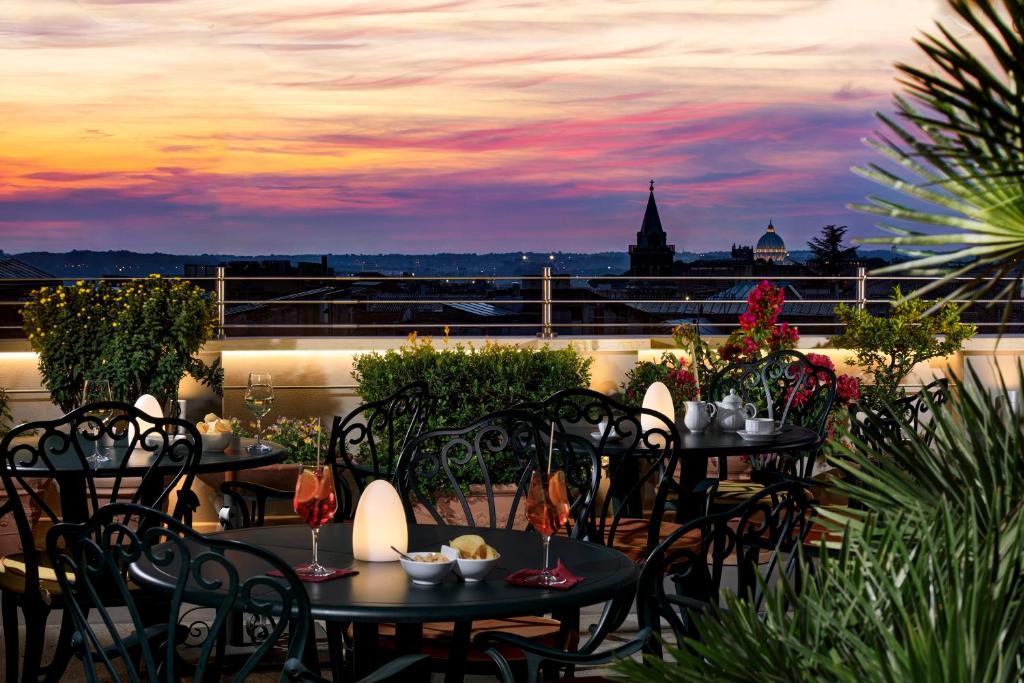 罗马Marcella Royal Hotel - Rooftop Garden的一个带桌椅的市景庭院