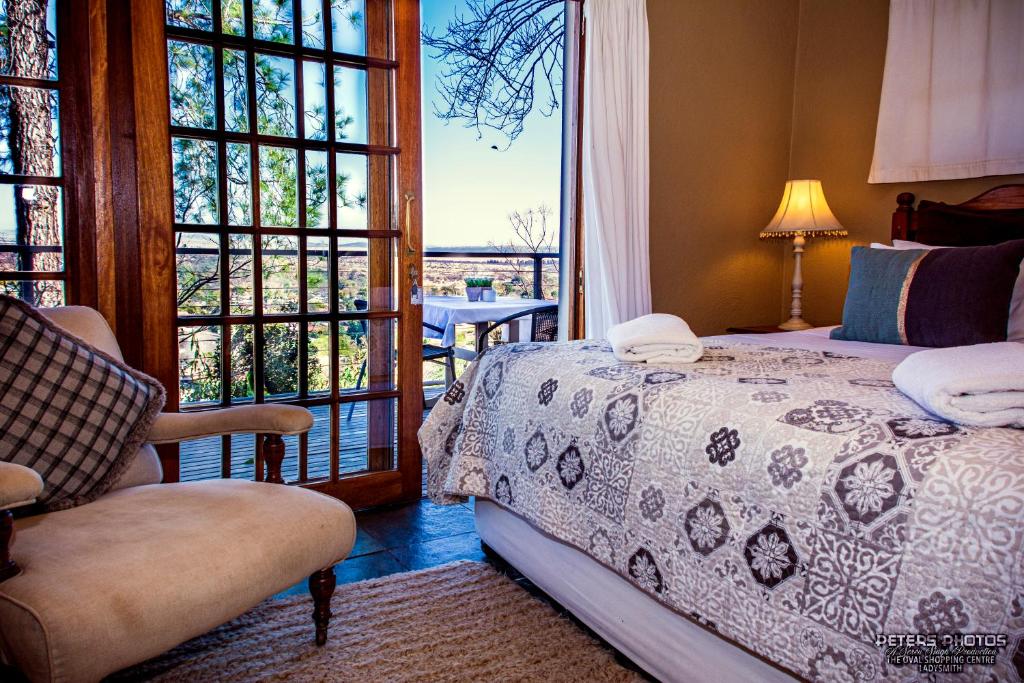 莱迪史密斯Buller's Rest Guest Lodge的卧室配有床、椅子和窗户。