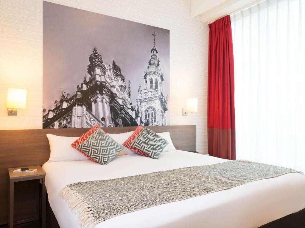 布鲁塞尔阿迪雅阁布鲁塞尔大广场公寓酒店的卧室配有一张带红色窗帘的大型白色床