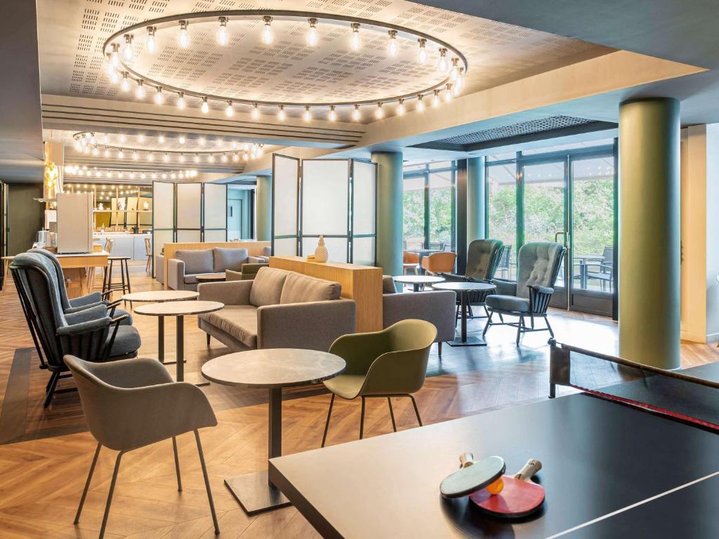巴黎凡尔赛宫阿德吉奥公寓酒店的酒店大堂设有桌椅和吊灯。