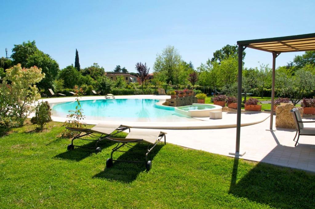 阿夏诺Sant'Ippolito的庭院内一个带桌椅的游泳池