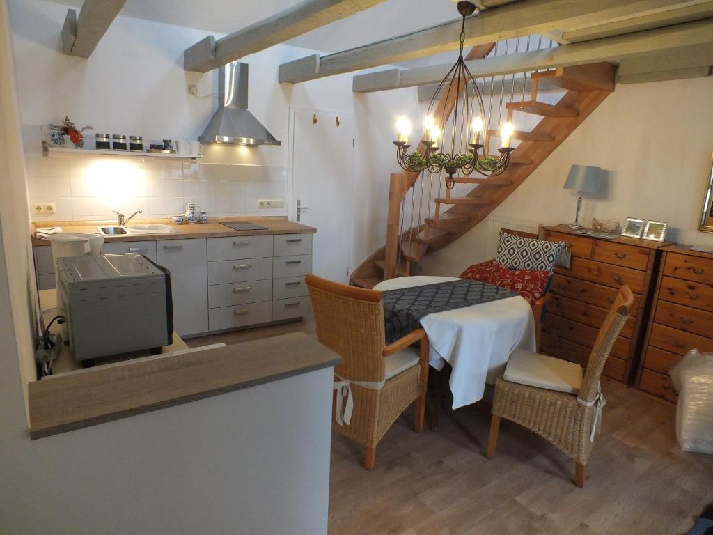 诺伊鲁平Maisonette "im Alten Pfarrhaus"的厨房以及带桌椅的用餐室。