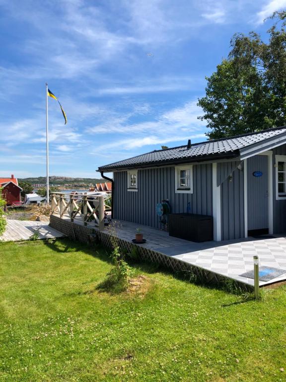 亨尼博斯特兰德Hunnebostrand, Ramsviklandet, Smögen, Bohuslän, Vestkusten的一座带甲板和旗帜的小房子