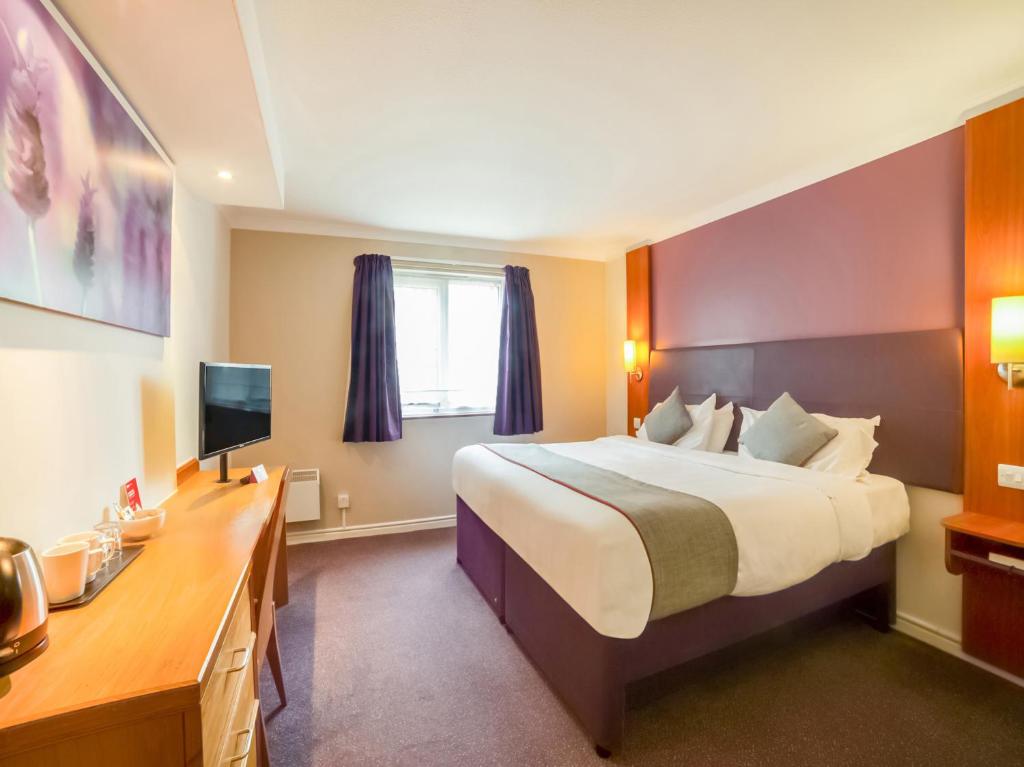 圣海伦斯OYO Lakeside Haydock Hotel, St Helens的酒店客房设有一张大床和一张书桌。