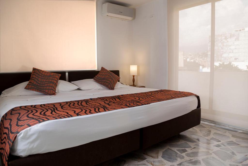 卡利卡利火烈鸟酒店的一间卧室设有一张大床和大窗户