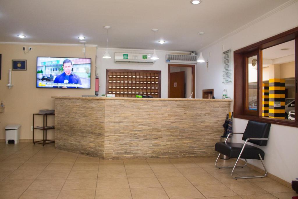 博伊图瓦Hotel Garrafão - localizado no centro comercial de Boituva - SP的一间位于等候室的酒吧,墙上配有电视