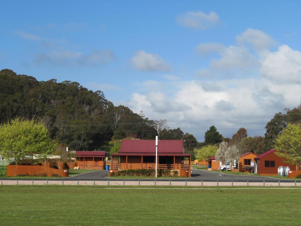 LatrobeLatrobe Mersey River Cabin and Caravan Park的道路一侧有红色屋顶的建筑