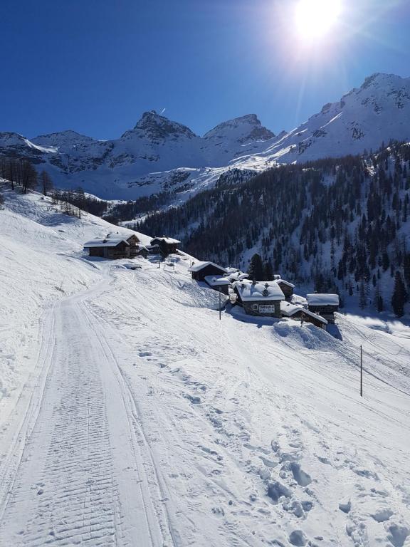 尚波吕克L' Aroula Rooms & Restaurant的一座雪覆盖的山,山中设有滑雪场,