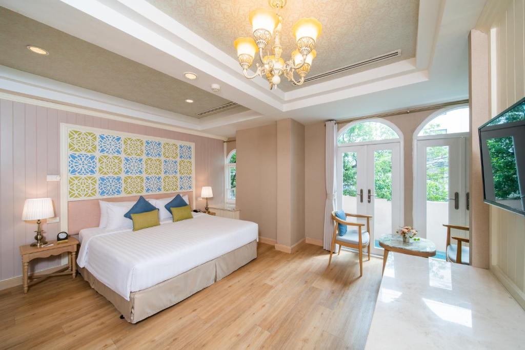 曼谷拉普提萨利尔素坤逸8的卧室配有白色的床和吊灯。