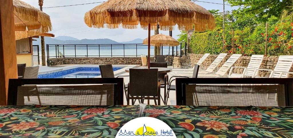 乌巴图巴马尔普拉亚酒店的一个带桌椅的庭院和一个游泳池