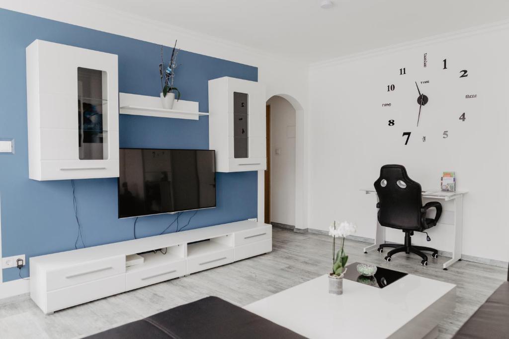 盖尔森基兴SK Apartments - Blue的一间客厅,客厅的蓝色墙壁上配有电视