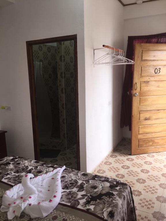 圣伊格纳西奥Matus Guest House的一间卧室配有一张床和一个衣柜及一扇门