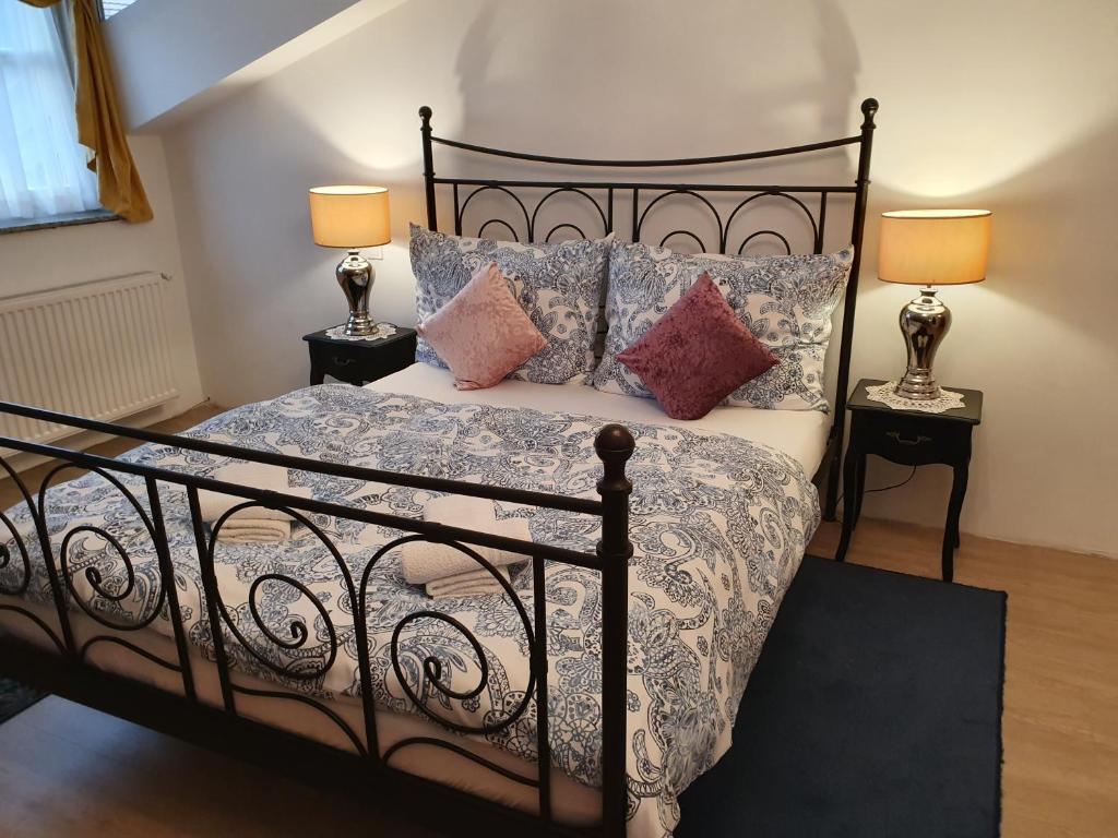 索普隆Karmelita Boutique Apartman的一间卧室配有一张带枕头的黑色床和两盏灯。