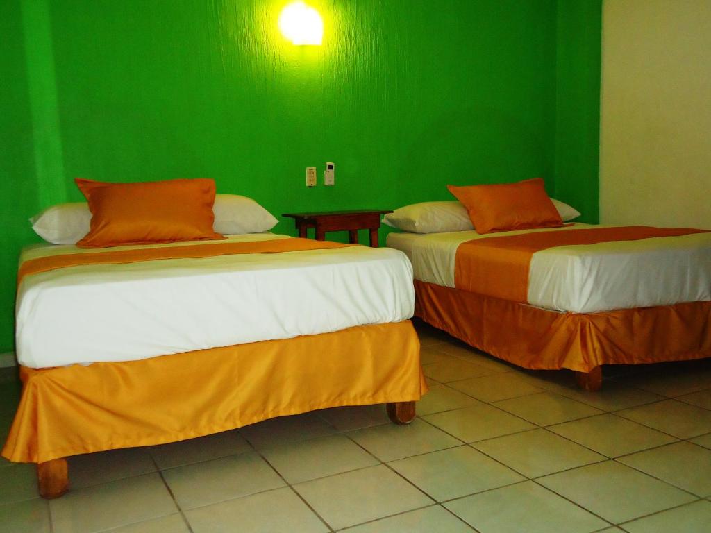 巴拉德纳维达Casa Mexicana Barra de Navidad的绿墙客房内的两张床