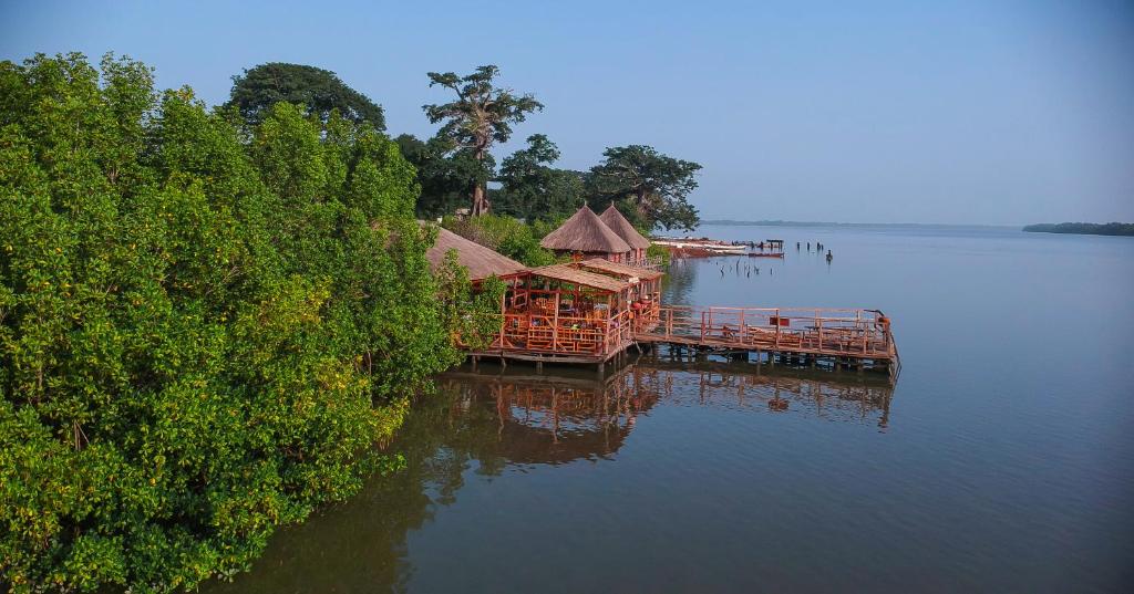 宾当Bintang Bolong Lodge的湖上的一个码头,上面有房子