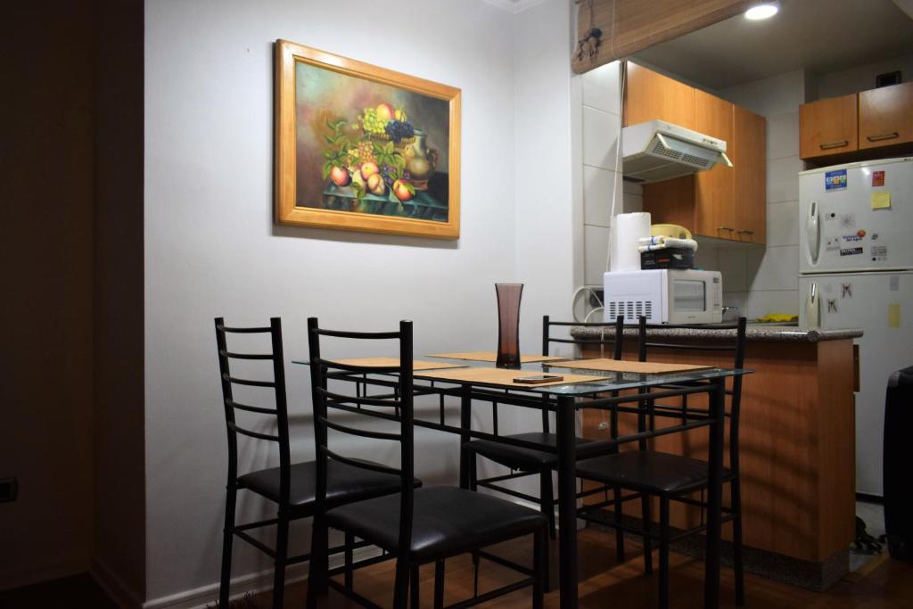 圣地亚哥Dpto 1D 1B, Metro Bellas Artes, equipado full con WiFi的厨房配有桌椅和墙上的绘画作品