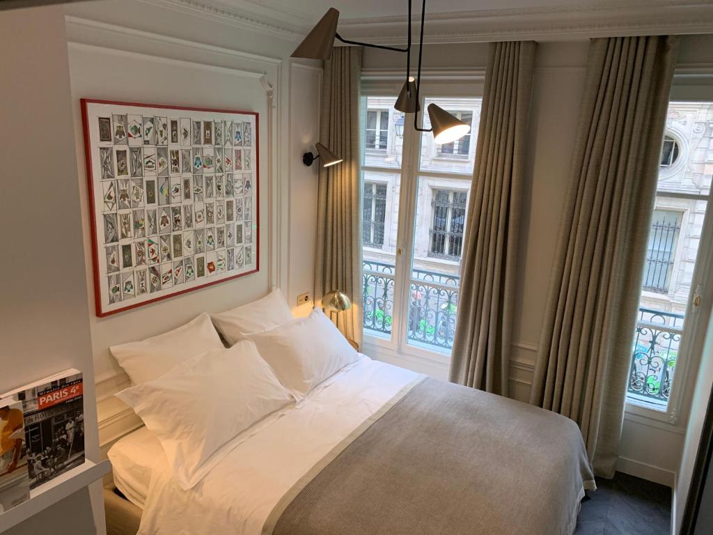 巴黎PARIS RIVOLI NOTRE DAME Chambre d'Hôtes Studio Private的卧室配有白色的床和2扇窗户。