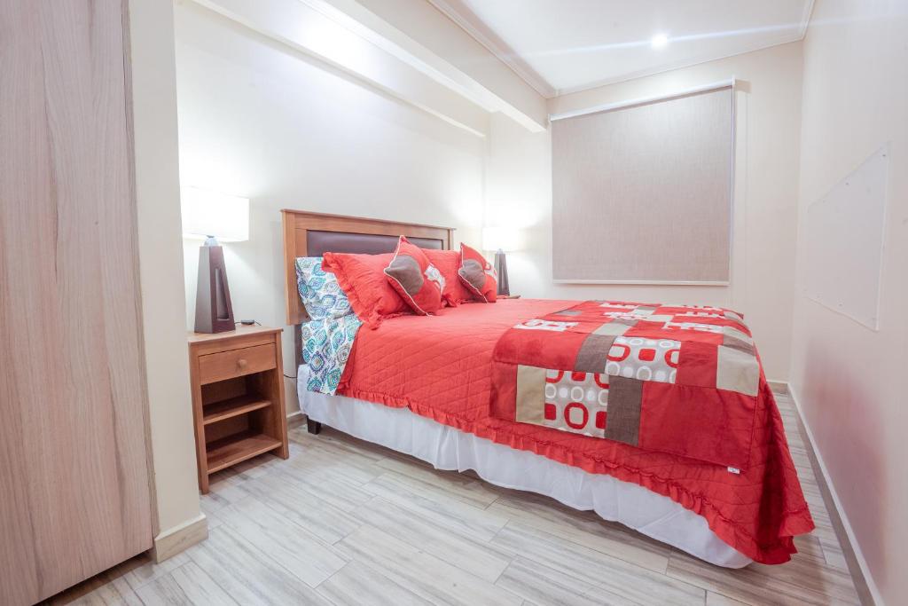 圣地亚哥Santiago Rent Apart的一间卧室配有一张红色棉被的床