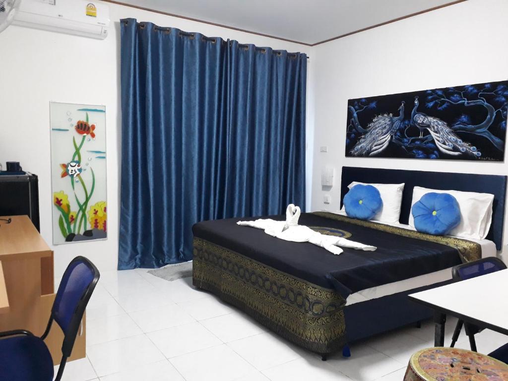 卡图B&B NAMO PHUKET的一间卧室配有床和蓝色窗帘