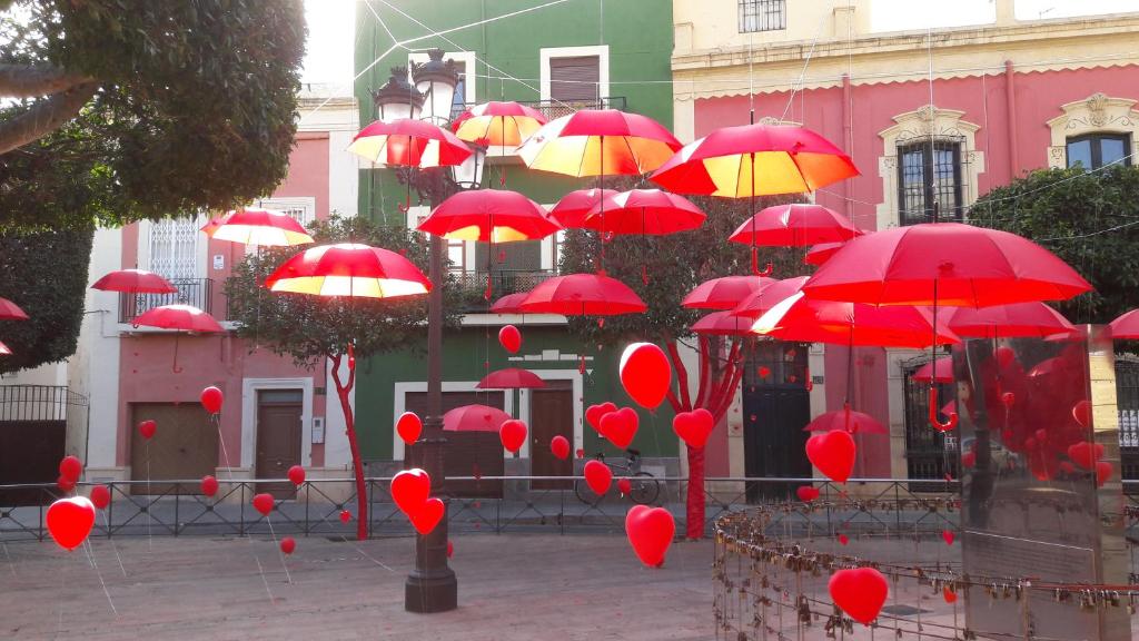 阿尔么丽亚La Pita Guesthouse的大楼前的一大堆红伞