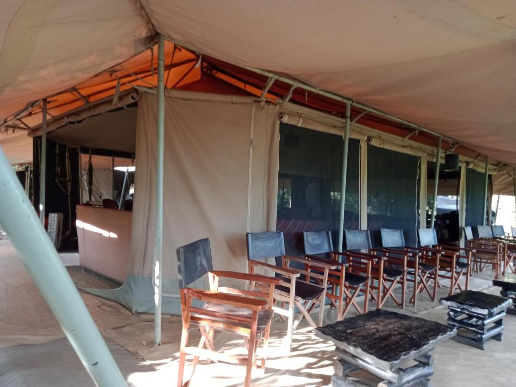 塔勒克玛拉兰奇野生动物观赏露营地 - 马赛马拉国家保护区的一组椅子坐在帐篷下