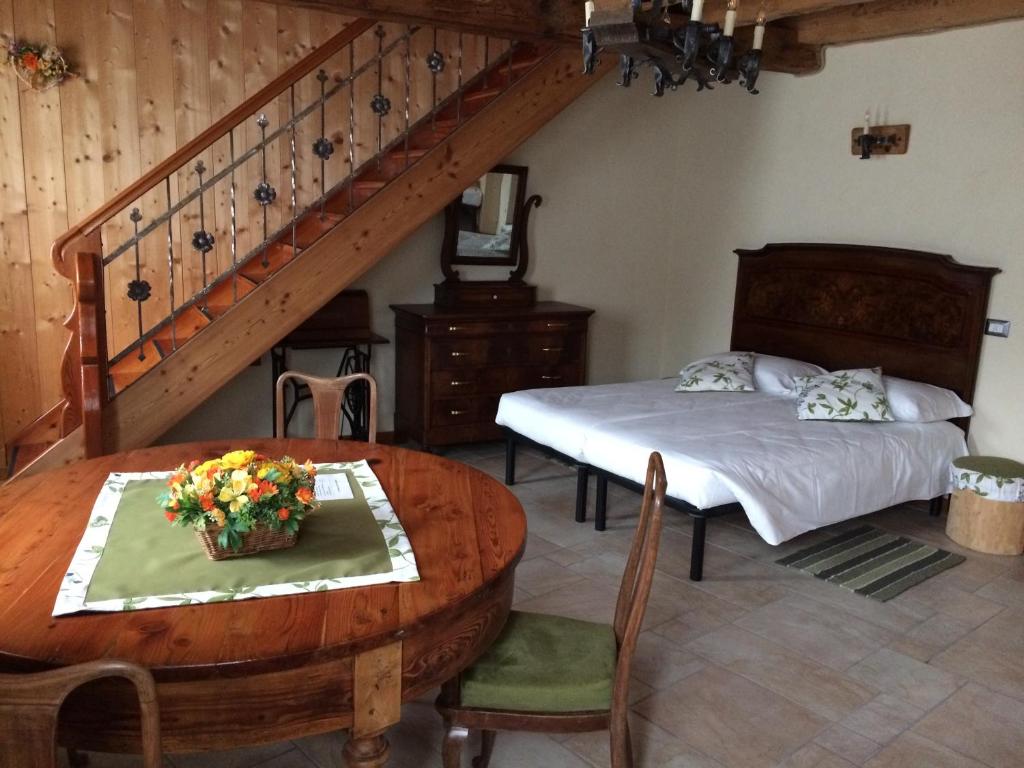 BianzoneAgriturismo Antico Filare的一间卧室配有一张床、一张桌子和一个楼梯