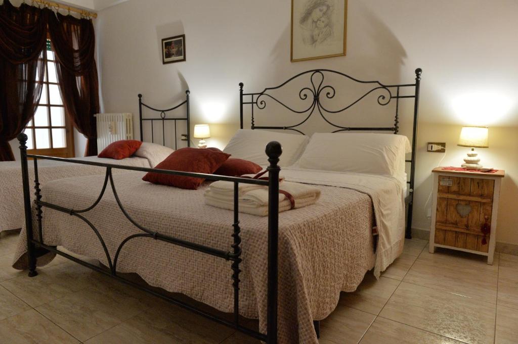 阿尔贝罗贝洛Dimora Carmine的一间卧室配有带白色床单和红色枕头的床。