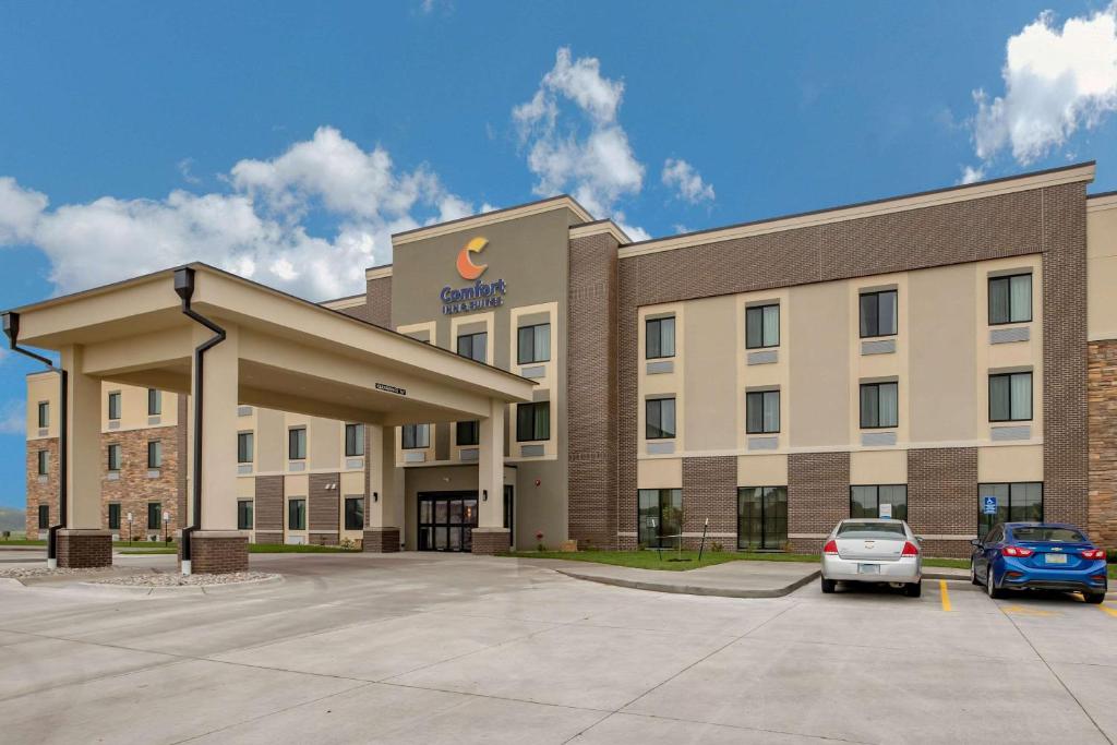 埃姆斯Comfort Inn and Suites Ames near ISU Campus的停车场内有车辆停放的办公楼