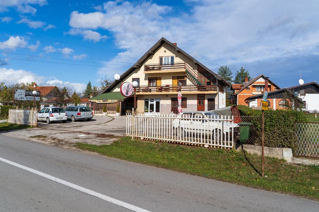 兹拉蒂博尔Guest house Padine Zlatibora的街道前有白色围栏的房子