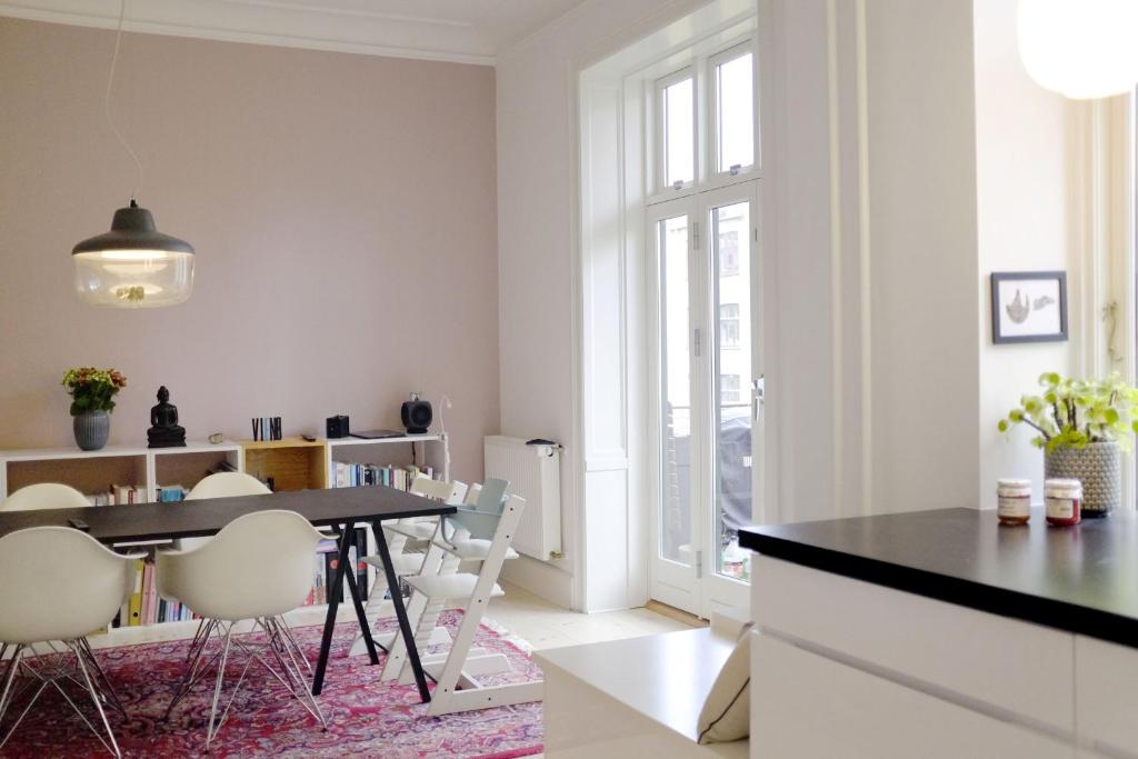 哥本哈根ApartmentInCopenhagen Apartment 1357的一间带桌子和白色椅子的用餐室