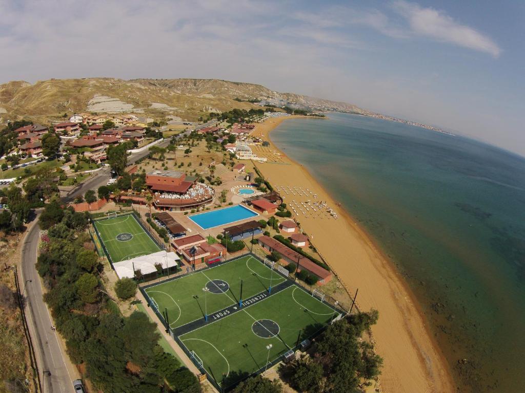 克罗托内hotel villaggio Casarossa的享有海滩空中美景,设有网球场