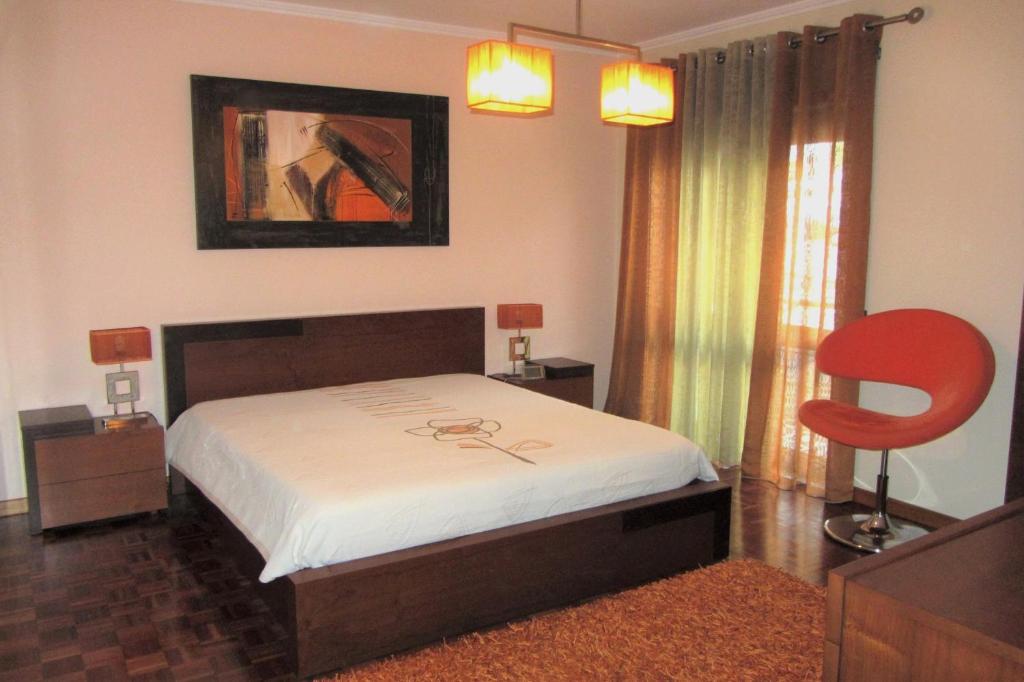 加亚新城Apartamento Superior Helena's Porto Corner的一间卧室配有一张床和一张红色椅子