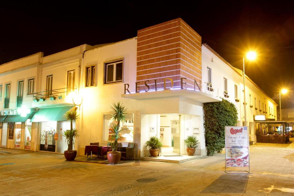 卡帕里卡海岸海和太阳酒店的一座建筑,在晚上前有标志