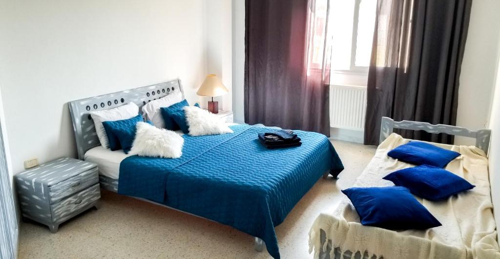 马赫迪耶Mahdia Place Apartments的一间卧室配有蓝色的床和蓝色枕头