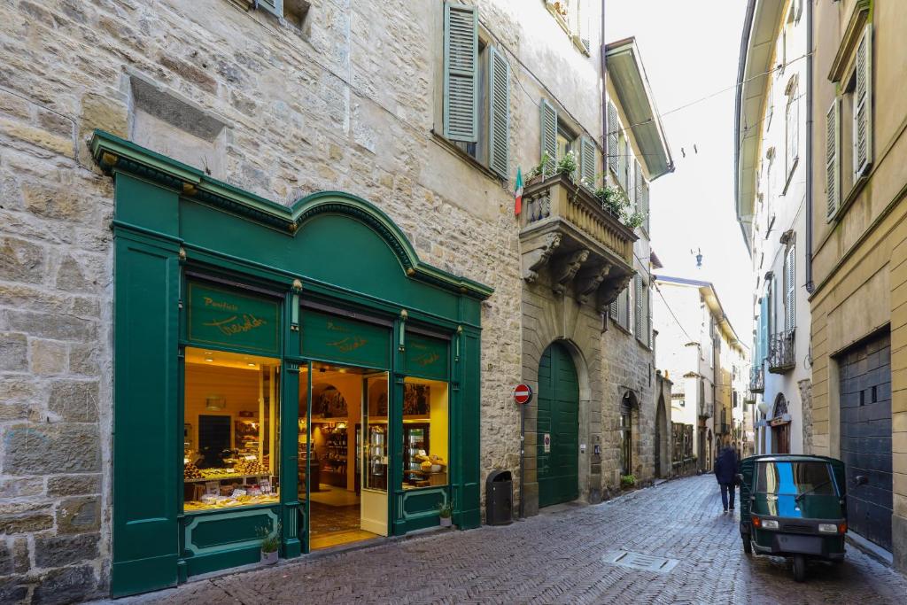 贝加莫Altana Bergamo Home的街道上一座绿色商店的建筑