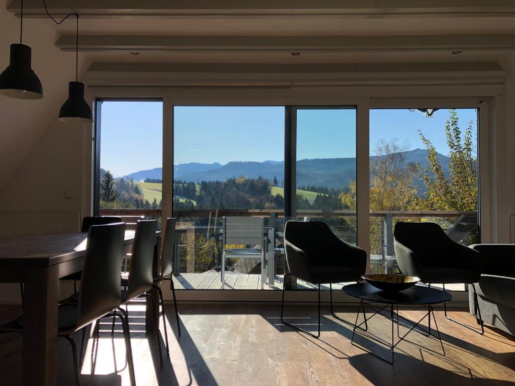 希格斯多夫Haus mit Bergblick的一间带桌椅和大窗户的用餐室