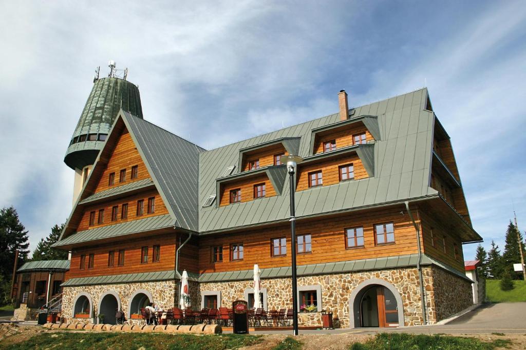 Orličky克拉莫洛瓦酒店的一座大型木结构建筑,带有金属屋顶