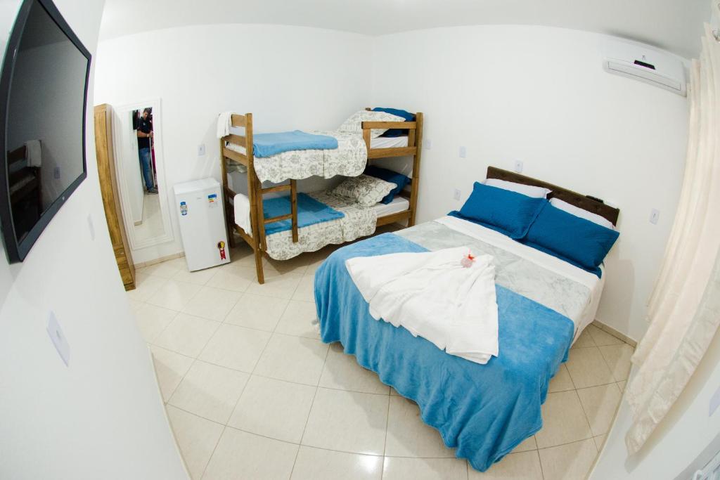 佩尼亚PÉROLA SUÍTES - PENHA的一间卧室配有蓝色和白色床单