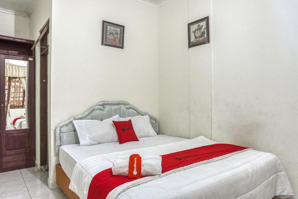 KalasanRedDoorz Syariah @ Raya Tajem Maguwo的一间卧室配有一张带红色毯子的床