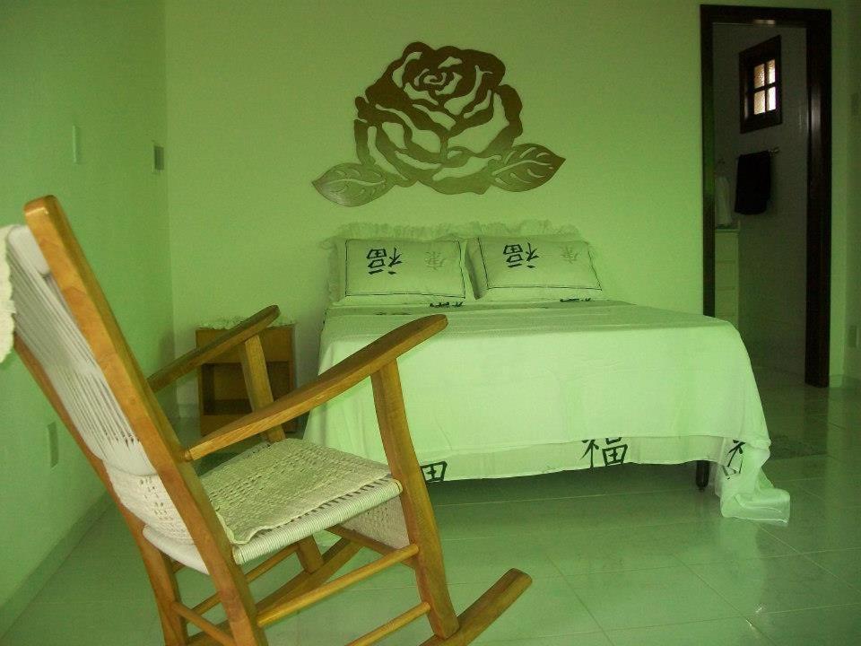 伊尔哈德博伊巴Recanto Solar da Paz的一间卧室配有一张床和一把摇椅